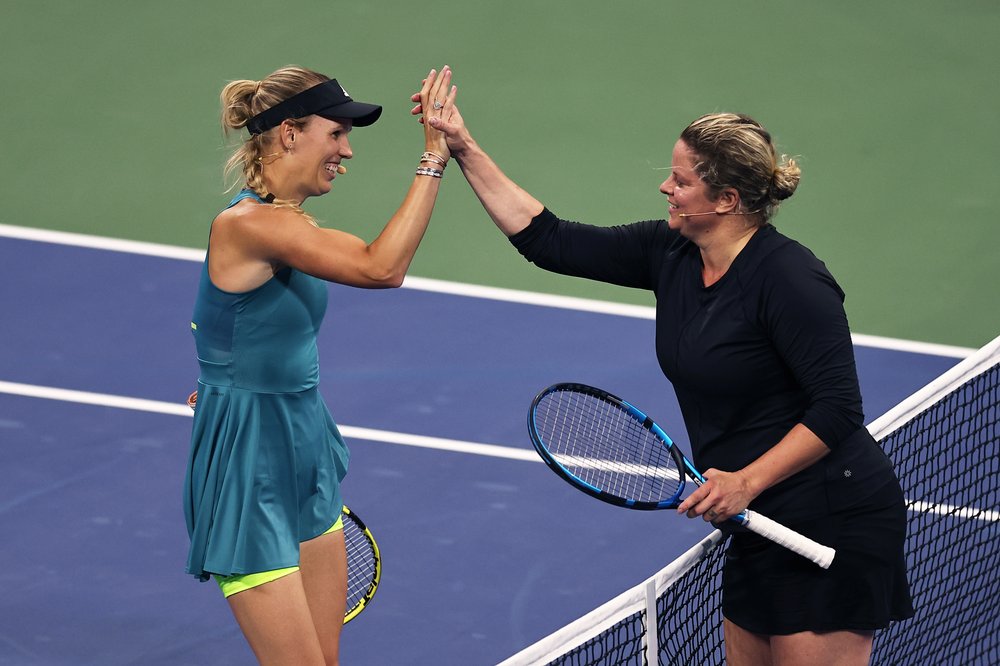 Two women high five on a tennis court.
