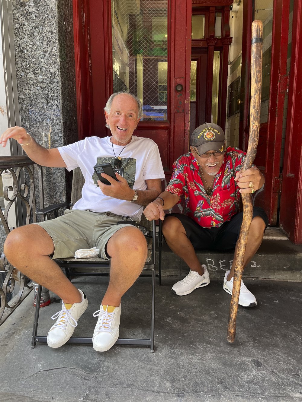 Two friends sit in front of a building