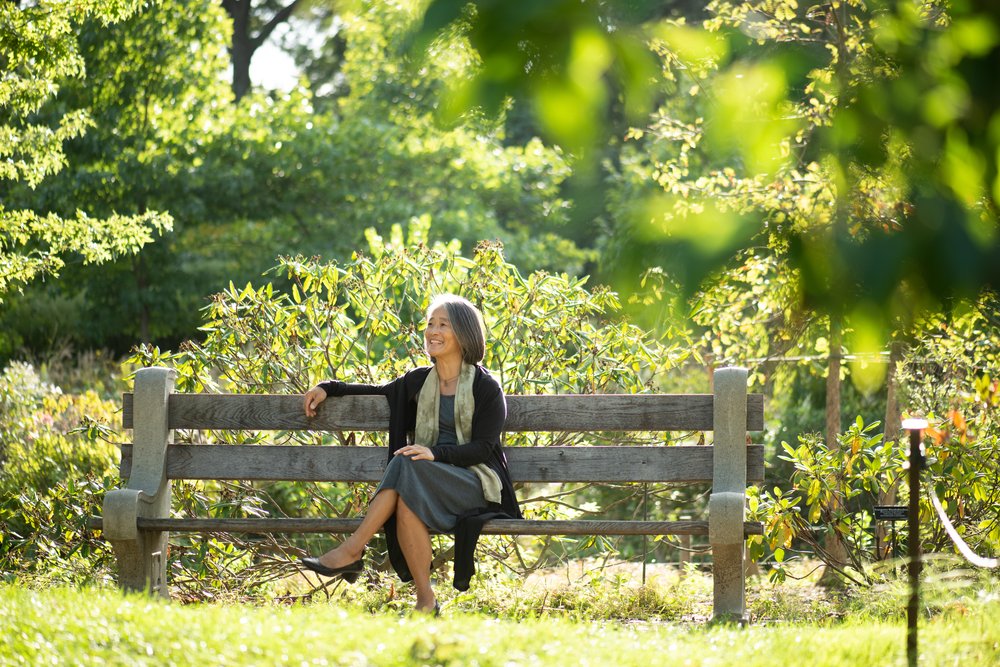 A woman sitting on a park bench.
