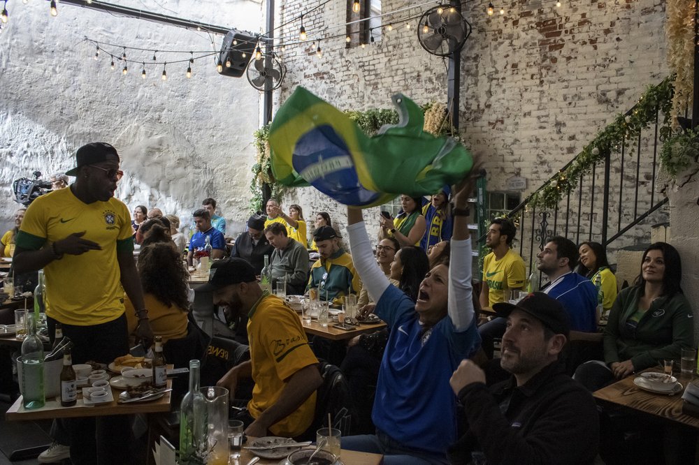 Supporters of the Brazilian soccer team celebrate in a bar.