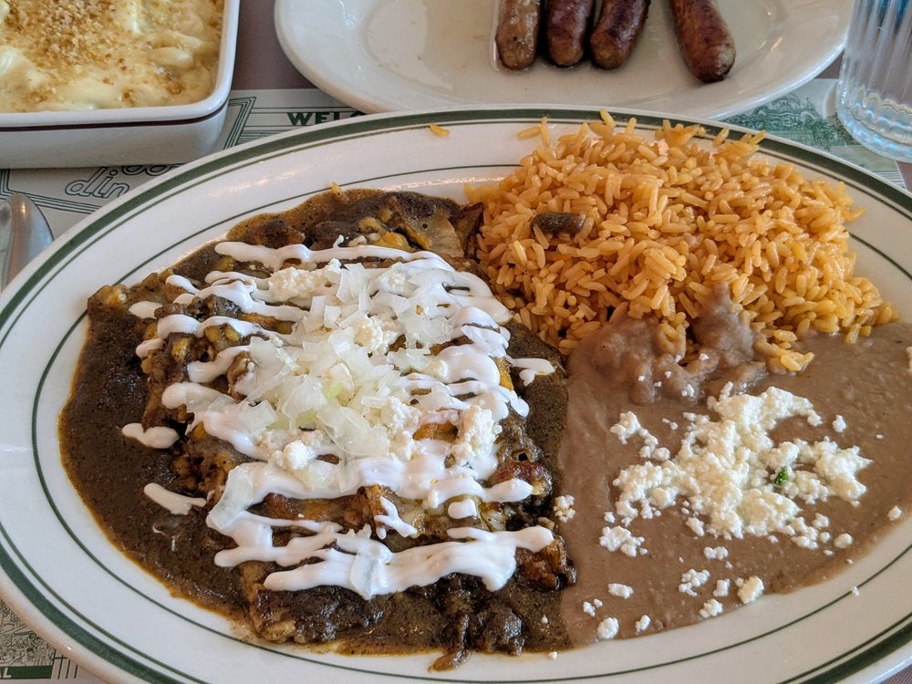 A plate of rice and beans with white cheese drizzled on top.