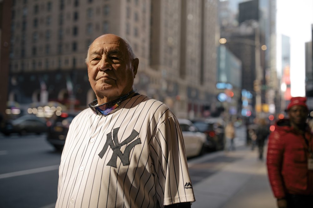 As Times Square bustles with tourists and the sounds of traffic, Don Bridges, an avid Yankee fan and season ticket holder, stands for a portrait outside the Manhattan Hotel at 790 7th Avenue before taking the D train to the Yankee Tavern in the Bronx borough of New York City, New York, U.S., on Saturday, October 22, 2022