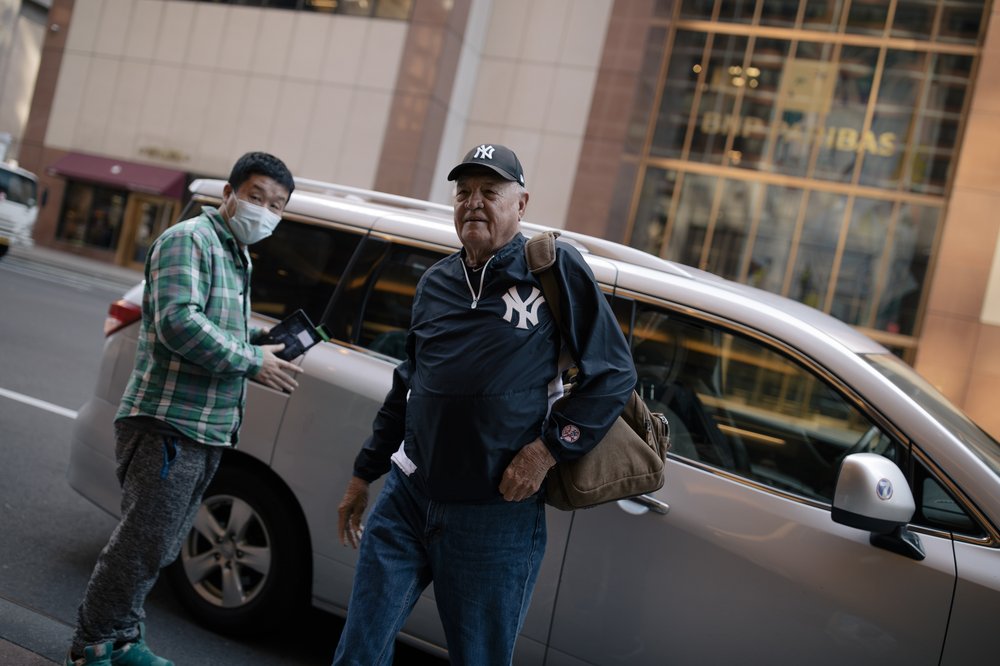 Don Bridges, wearing a Yankees jacket and hat, arrives at The Manhattan at Times Square Hotel.