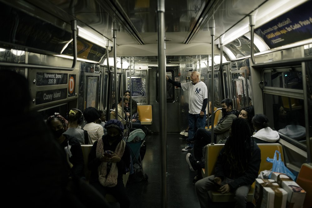 Don Hudson, in his number 8 Yankees jersey, rides the subway.