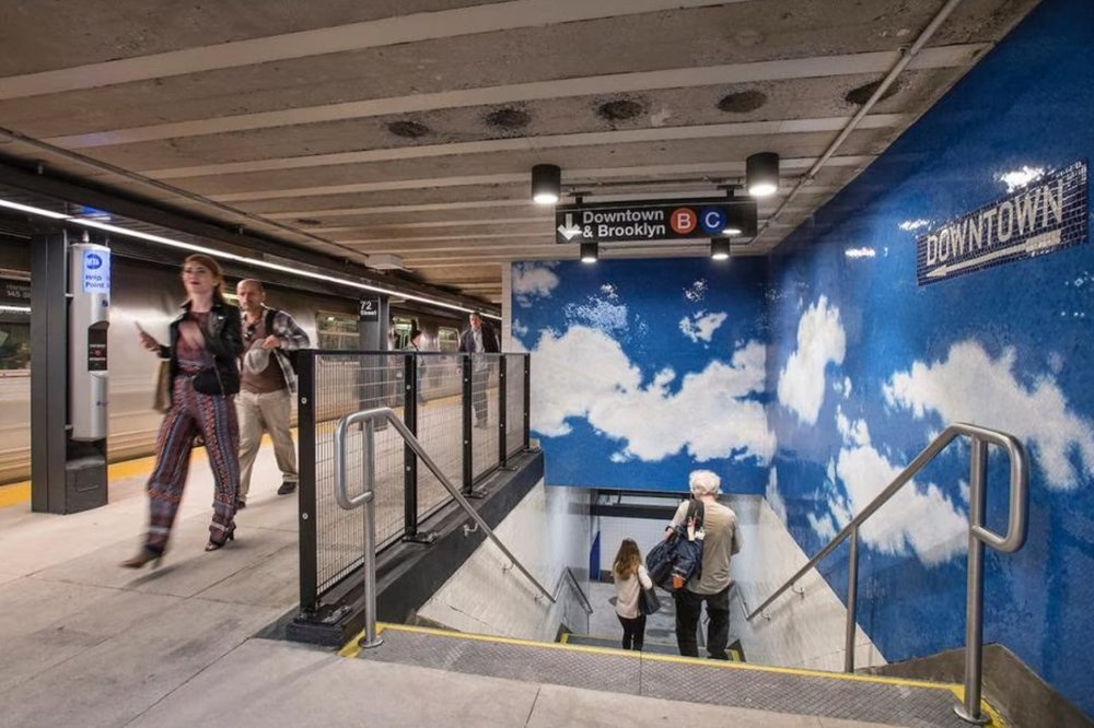 mosaics appear like cloud-filled skies on the wall of a subway station