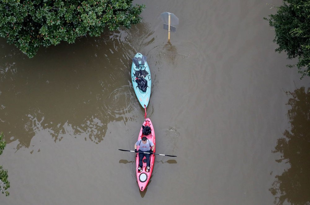 A man kayaks into an area near flooded homes near Lake Houston following Hurricane Harvey August 29, 2017 in Houston, Texas<br>(Getty Images)