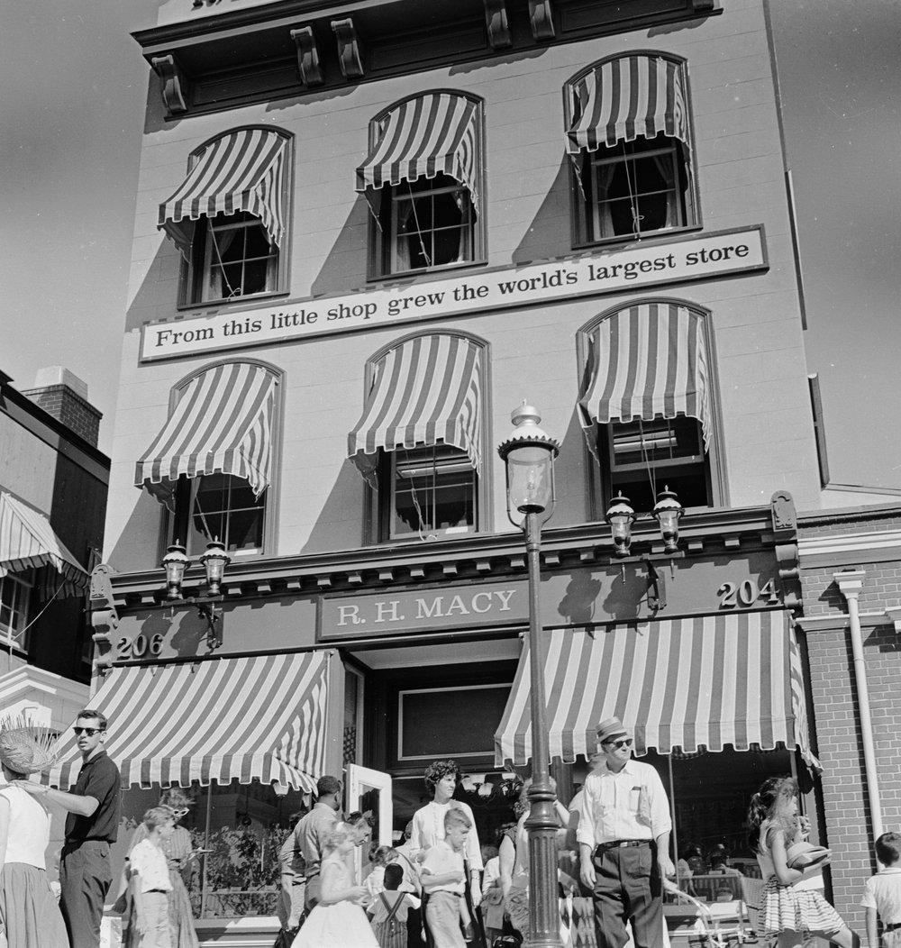 aa348b5c4.jpeg "Striped awnings cover the windows of R H Macy, a historical shop in Freedomland Park, a Wild West themed park in the Bronx, New York City. August 1960."