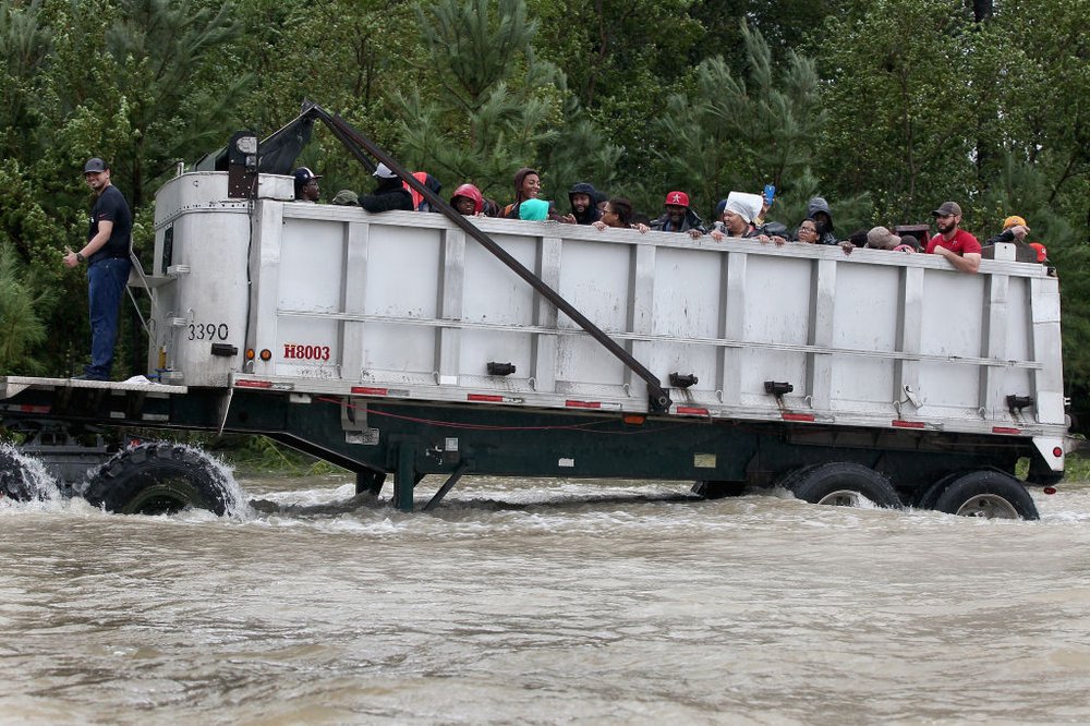 Rescue workers and volunteers help residents make their way out of a flooded neighborhood after it was inundated with rain water following Hurricane Harvey on August 29, 2017 in Houston, Texas.<br>(Getty Images)