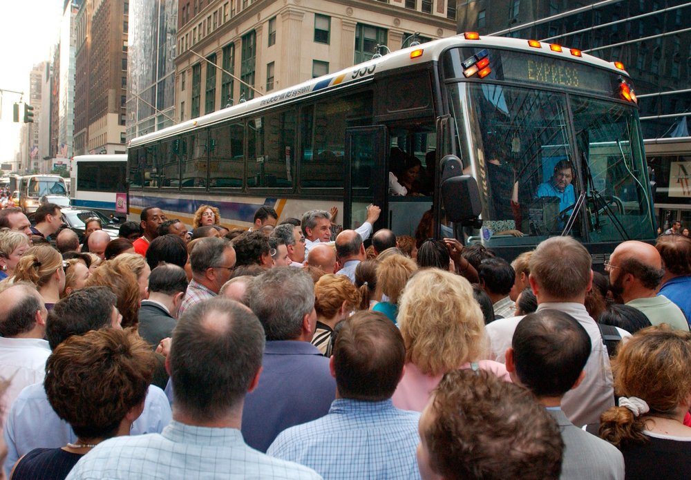 Commuters crowd around a bus in Midtown on August 14, 2003 (LOUIS LANZANO/AP/Shutterstock)