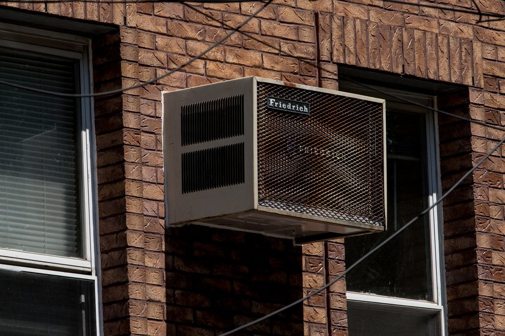 An air conditioner is seen in the wall of an NYC residence on July 28, 2020. During the pandemic's first summer, city officials gave out free air conditioners, and the program had a noticeable impact on people's health and well-being.