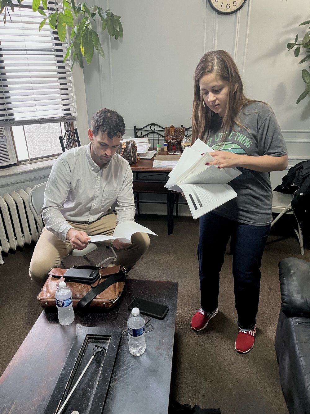 Barbara Quiñones-Wallace, the daughter of one of the tenants being evicted by Maimonides, goes over documents with Tyler Crawford, a Legal Aid attorney working on the case.