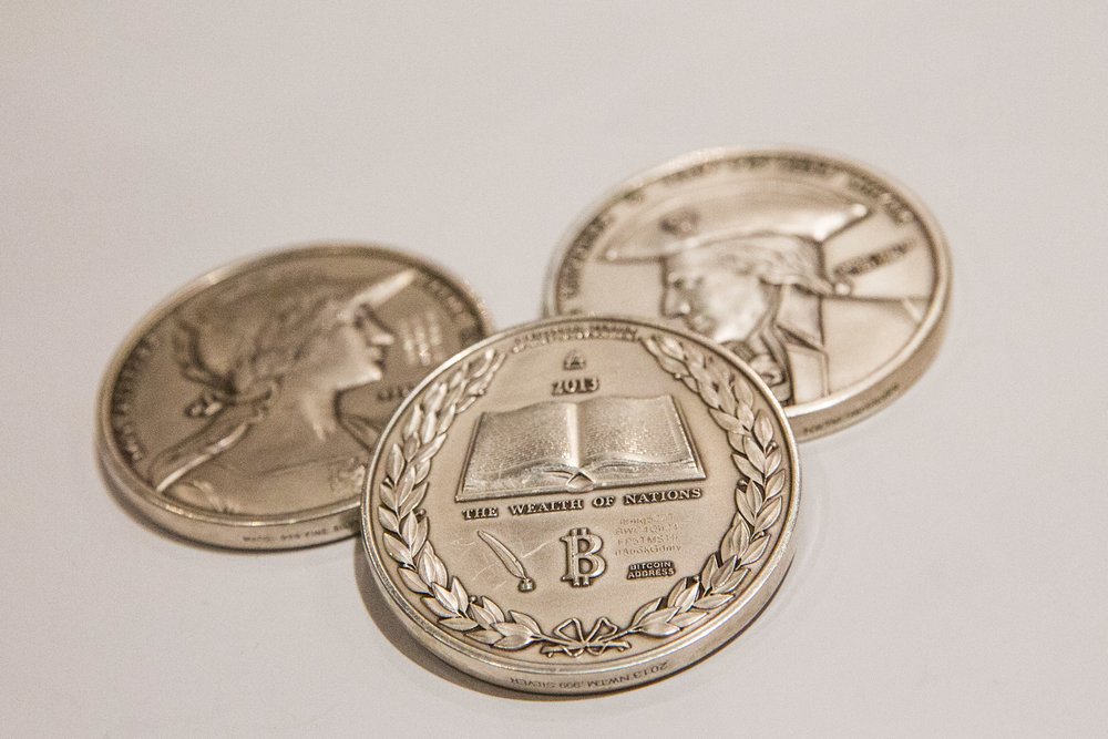 Silver coins with the Bitcoin logo on them are displayed at a Bitcoin conference on at the Javits Center