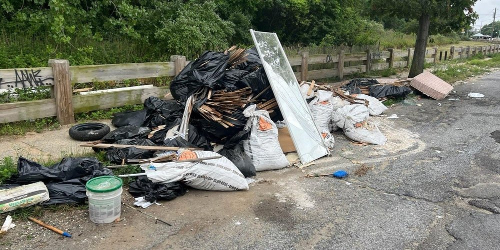 A pile of construction debris left on the side of road.