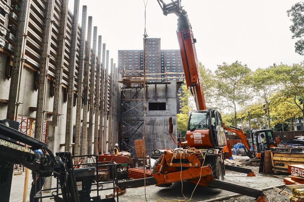 NYCHA is building a new pneumatic garbage system at the Polo Grounds development that will whoosh garbage and recycling at 60 mph in tubes from the apartment towers to this new terminal building for processing.