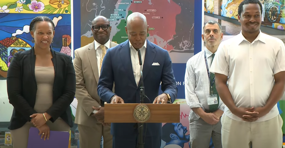Mayor Eric Adams addresses reporters in Harlem on Thursday.