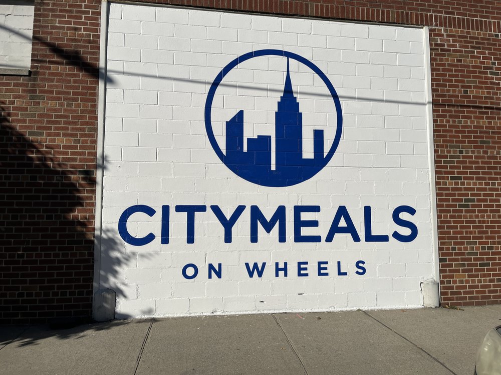 A Citymeals on Wheels sign is painted on the outside of the nonprofit’s giant warehouse in the Bronx.