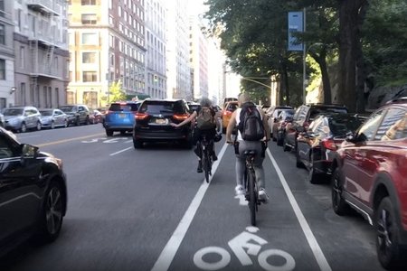 Cyclists forced into traffic by a cab blocking the currently unprotected bike lane on Central Park West. JAKE OFFENHARTZ/GOTHAMIST