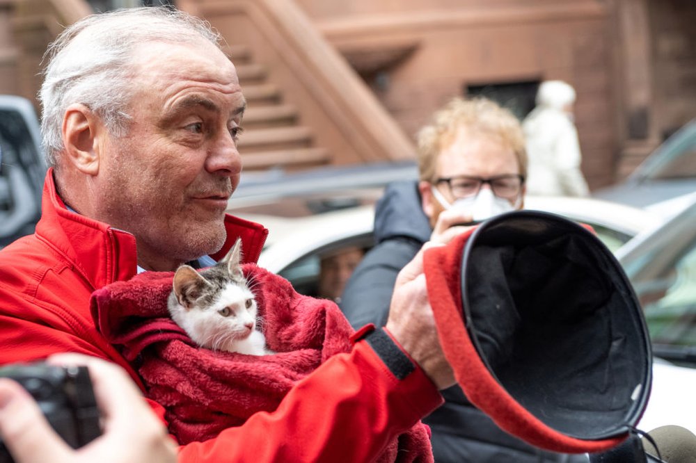 Curtis Sliwa holding a cat and removing his beret
