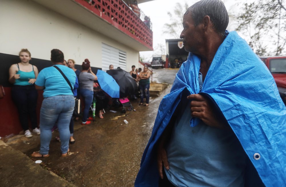 d19619c8bgettyimages-859577792-jpg.jpeg : Arian Rodriguez covers himself with a tarp as residents wait in the rain to register with FEMA more than two weeks after Hurricane Maria hit the island, on October 9, 2017 in Jayuya, Puerto Rico. <br/>