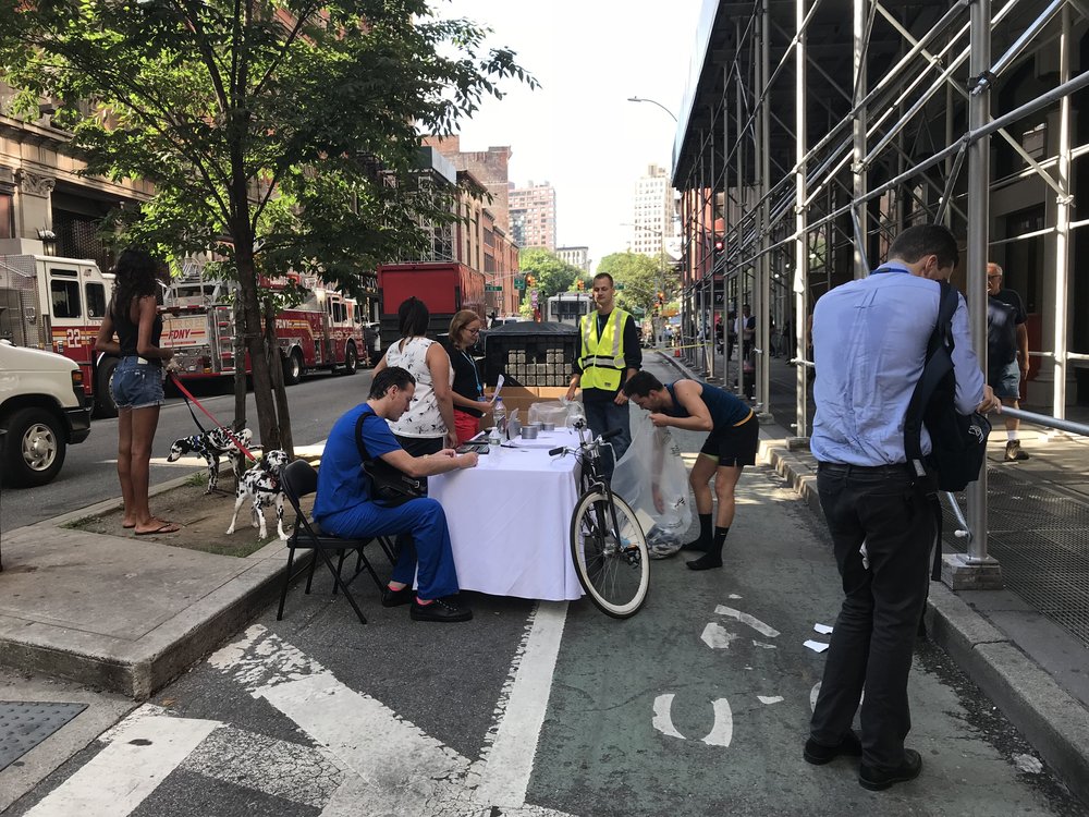 Dropping off contaminated belongings at 19th Street and Broadway. Dr. Neal Blitz sitting in blue, Steven Butschi with bike. (Jen Chung / Gothamist)