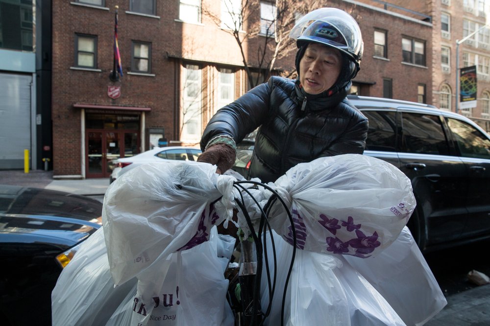 d448406032018-01-18_heinsebikedigital-1-jpg.jpeg A delivery cyclist in Midtown struggles to secure all his orders (at least ten) onto his bicycle before setting out.<br/>