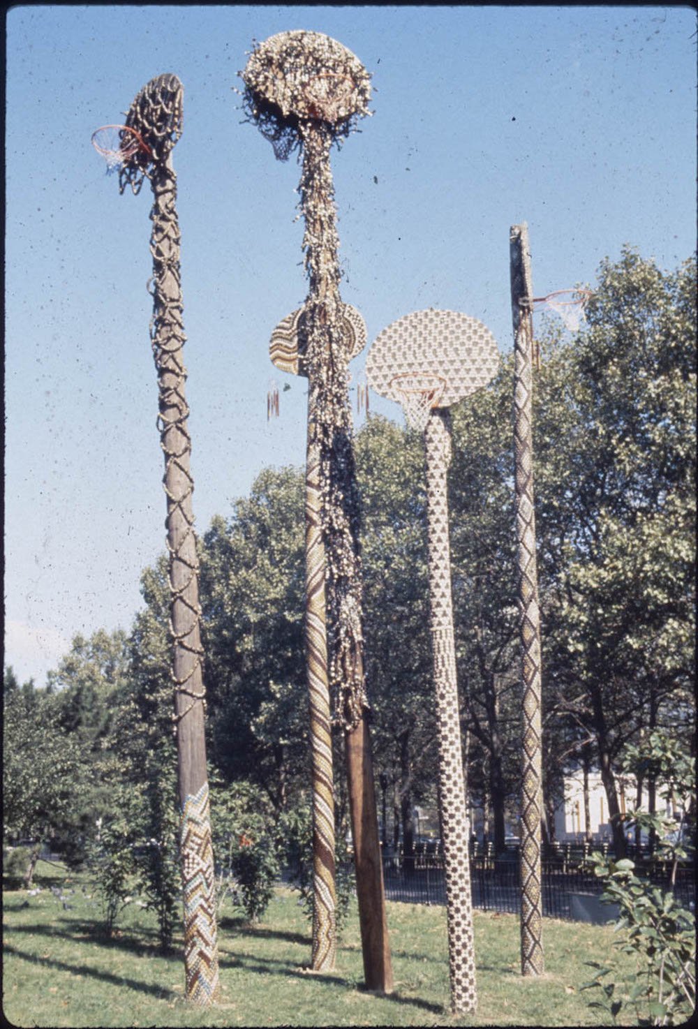 d9696e47416hammons-higher-goals-paf-1986-jpg.jpeg David Hammons, Higher Goals, 1986, Cadman Plaza Park, Brooklyn, photo by Pinkney Herbert and Jennifer Secor, courtesy of Public Art Fund. For Higher Goals, Hammons covered five telephone poles mounted with a basketball backboard and net with bottlecaps. Hammons stated, “It takes five to play on a team, but there are thousands who want to play—not everyone will make it, but even if they don’t at least they tried.”<br/>