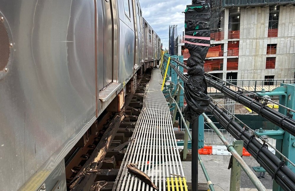 A photo of a train on the subway's F line just feet away from the edge of elevated tracks after it derailed.