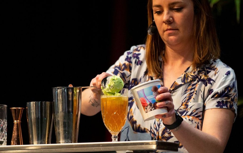 a bartender scooping ice cream into a cocktail