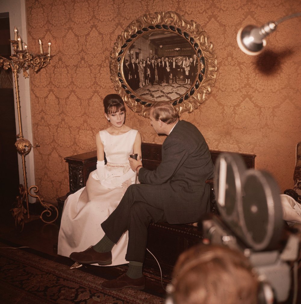 e0e7c5231.jpeg "Cameramen filming an interview with actress Audrey Hepburn at the Plaza Hotel. October 1961."