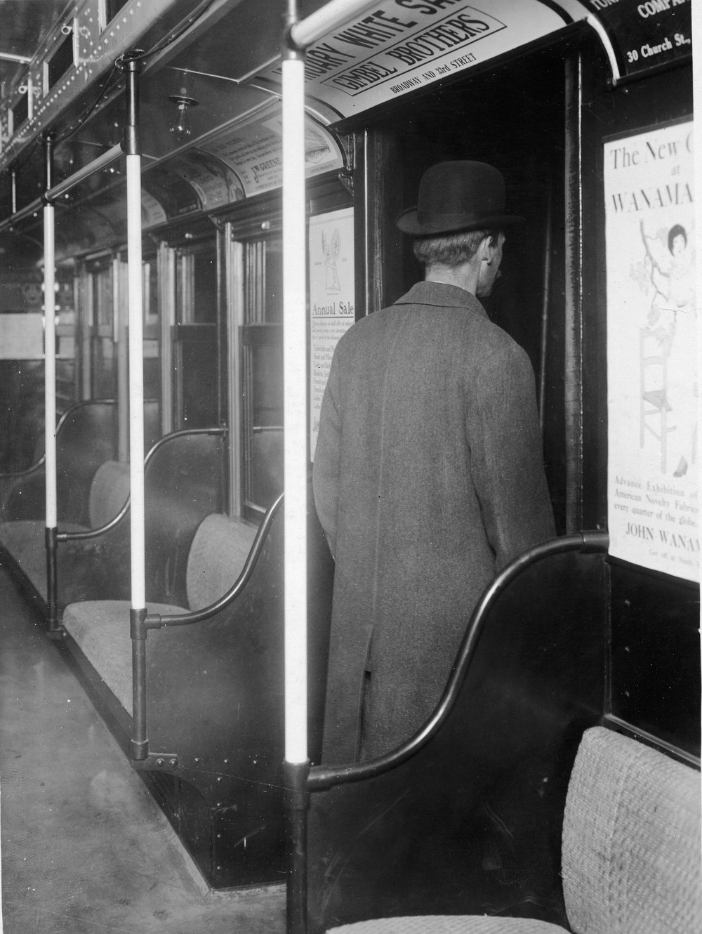 e47f8168agettyimages-51156913-jpg.jpeg A man in hat and coat gets off of a subway car the interior of which is plastered with advertising posters for department stores, New York, 1910s. (Getty)<br/>