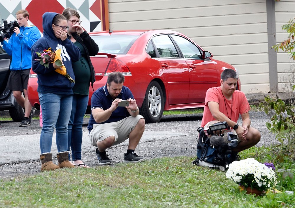 e4f758315shutterstock_9916971e-jpg.jpeg People place flowers, at the scene where 20 people died as the result of a limousine crashing into a parked and unoccupied SUV at an intersection a day earlier, in Schoharie, N.Y. (Hans Pennink/AP/Shutterstock)