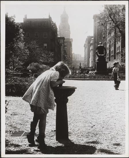 ecd8cc3bbmny18228-jpg.jpeg Office of War Information. 1944. View of a girl drinking out of a water fountain in Gramercy Park with the statue of Edwin Booth visible in the background. Visible beyond is the tower of the Consolidated Edison Co. Building at 4 Irving Place. (90.28.85)<br/>