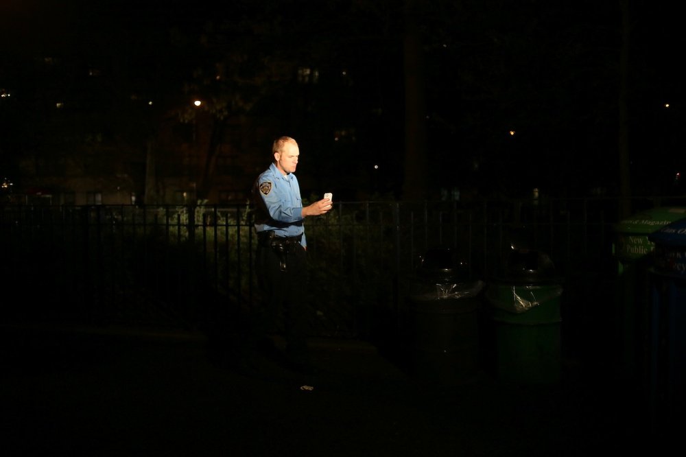 ef7ce73a3.jpeg An actor in retro police gear pauses to check his cell phone after a scene.<br/>