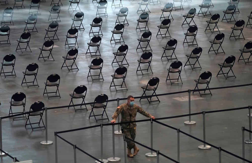 Member of the National Guard looks on as people stand in line at the Jacob K. Javits Convention Center.
