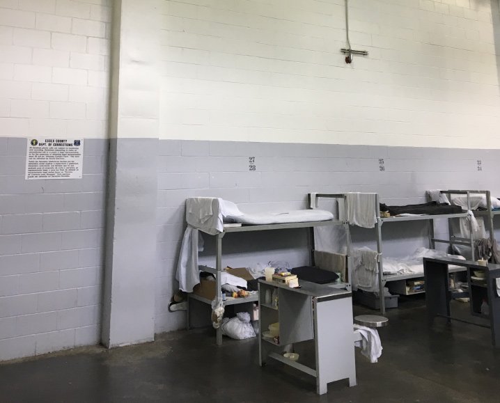 A bleak looking room with metal bunk beds and sparse furnishings