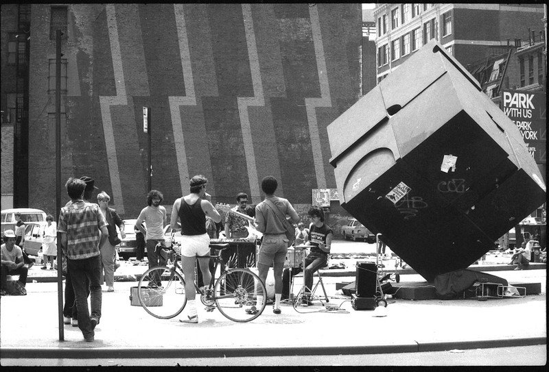 f399ec3259dac4332d00c5e471ada3e791e4915f6-jpg.jpeg Alamo Sculpture, mural, vendors, & musicians on Astor Place, looking south from 8th Street, between Lafayette Street and Cooper Square. 1980s.<br/>