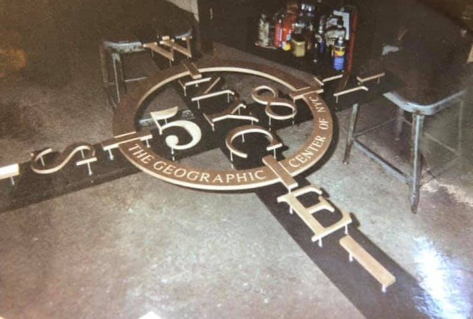 A brass or bronze "skeleton" is seen on the floor of a shop.