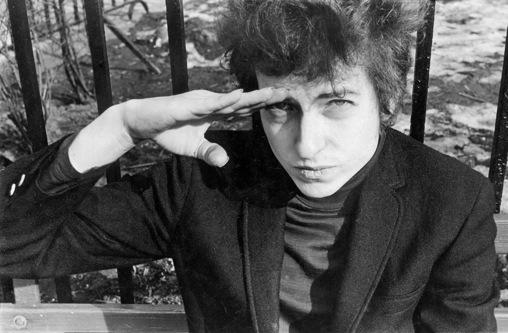ff574e415fredwmcdarrah_p115-jpg.jpeg Bob Dylan, sitting on a bench in Christopher Park (across the street from the offices of the Village Voice since 1960), either salutes or shields his eyes from the sun, January 22, 1965<br/>