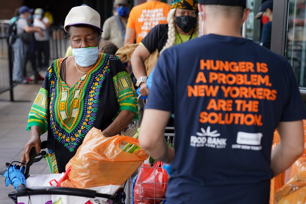 Pedestrians collect fresh produce and shelf-stable pantry items outside Barclays Center as Food Bank For New York City provides assistance to those in need due to the COVID-19 pandemic, September 10th, 2020