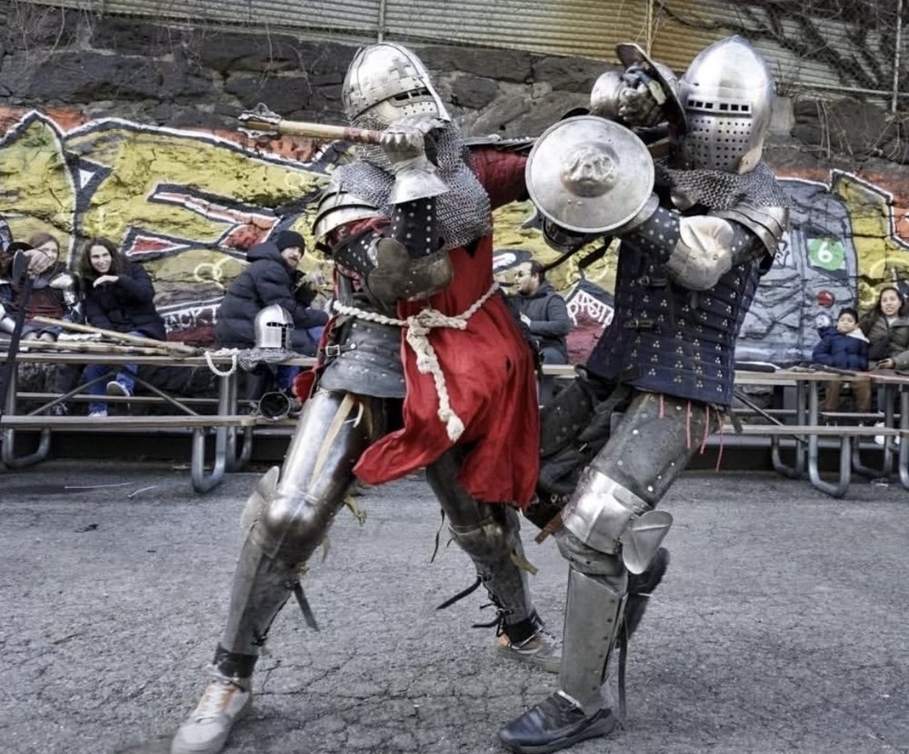 Two gladiators joust in armor.