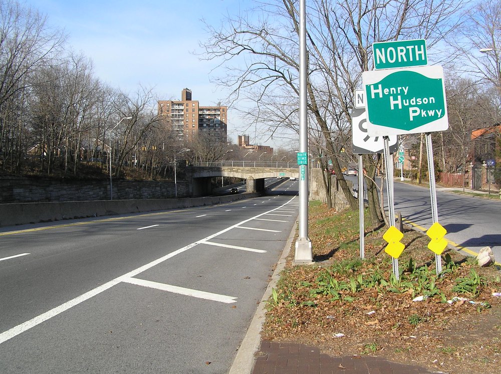 Green sign reads Henry Hudson Parkway North next to road