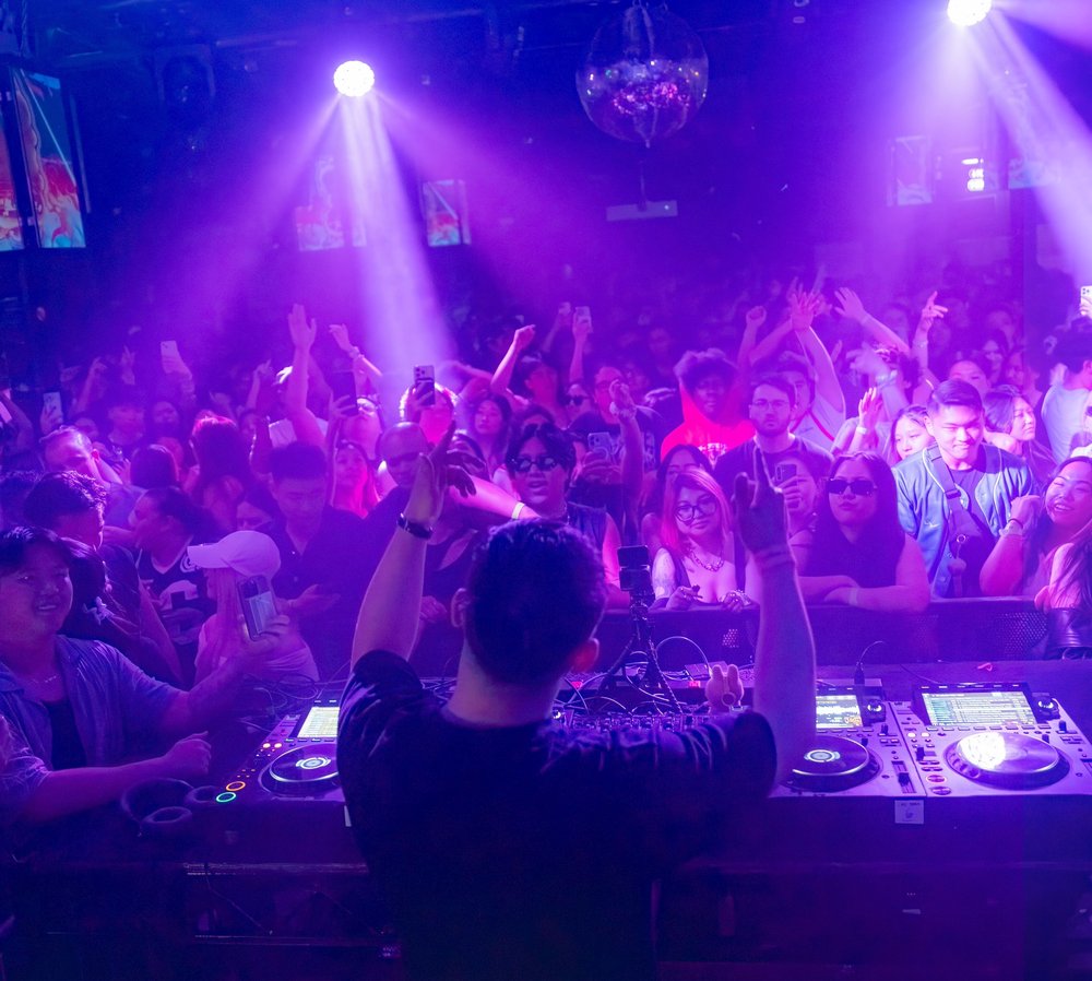 A party inside a club with purple lighting.