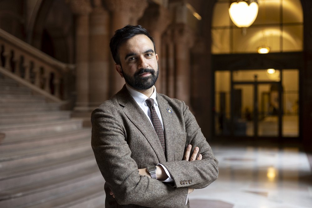 Zohran Mamdani with his arms crossed.