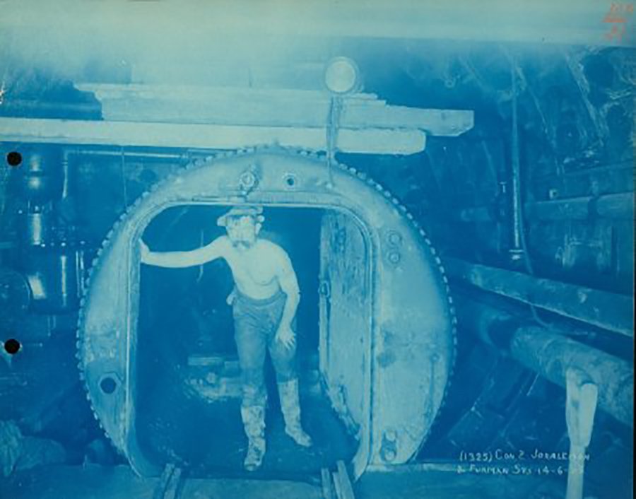 Photograph of a sandhog exiting the 'man-lock' between Furman and Joralemon Streets, Brooklyn during the construction of the IRT Lexington Avenue Line.