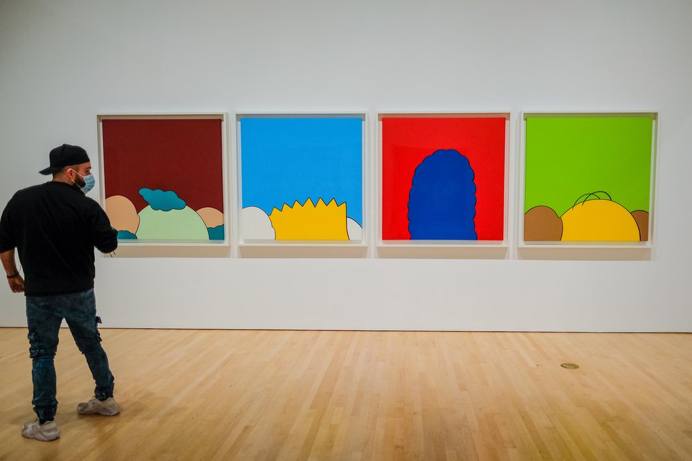 KAWS Brooklyn Museum Four paintings on wall. Inside the KAWS exhibit at Brooklyn Museum