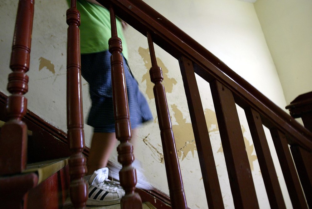 Children that have high levels of lead in their blood walk past a peeling lead paint wall July 25, 2003 in their Brooklyn apartment.