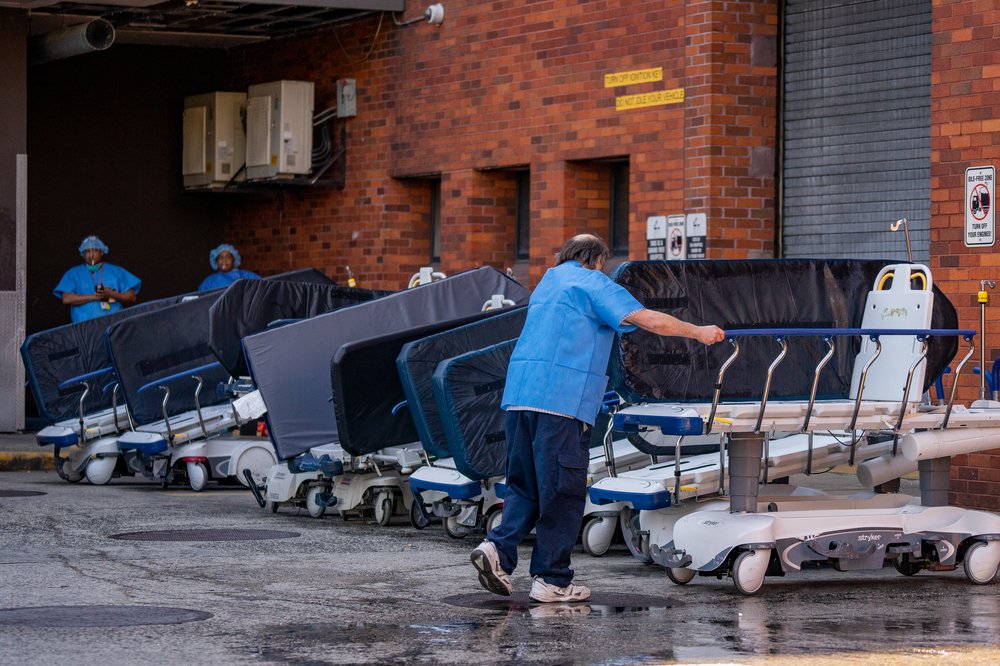 A worker from Lincoln Medical Center rearranges hospital beds that have been hosed off in the Bronx hospital's ambulance emergency room bay on April 16, 2020.
