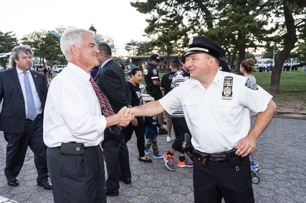 DA McMahon shaking the hand of a police officer