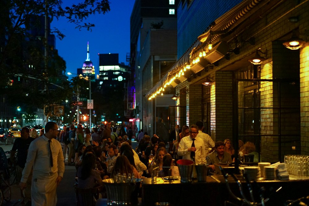 People dining outside on a NYC street.