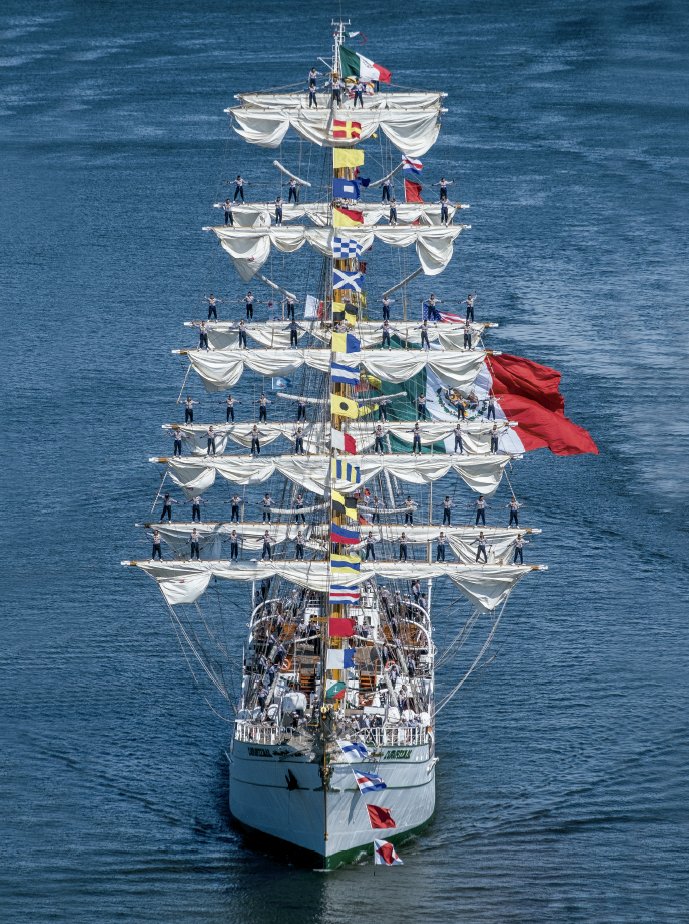 A group of sailors standing on the masts of a Mexican Navy ship.